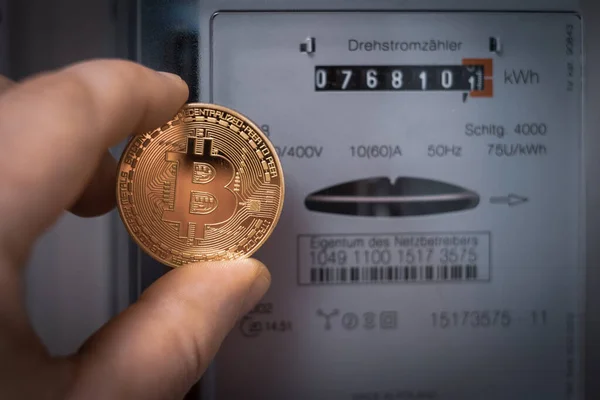 Bir el bitcoin 'i üç aşamalı bir metrenin önünde tutuyor.