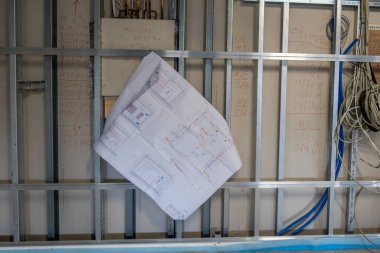 in the new operating room building, the construction plan hangs on a drywall