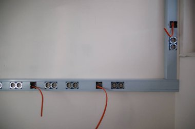 İnşaat alanında duvardan sarkan bir sürü kablo.