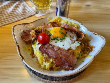 Tabakta kızarmış patates ve domuz pastırması var. 