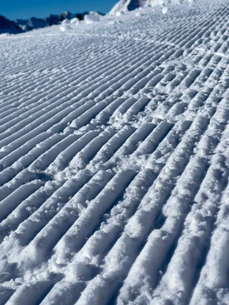 Zbliżenie Świeżo Przygotowanego Śniegu Stoku Niebo Jest Bezchmurne Niebieskie — Zdjęcie stockowe