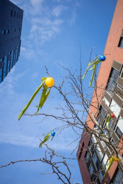 Büyük şehirde ağaçta asılı renkli paskalya yumurtaları