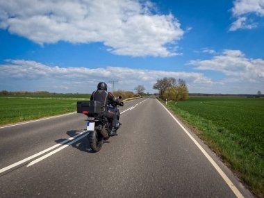 a motorcyclist rides his touring enduro over the country road