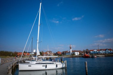 the port of Poel with the lighthouse in the background clipart