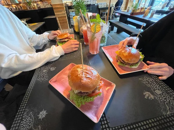 Een Tafel Staan Drie Borden Met Hamburgers Frietjes Drankjes — Stockfoto