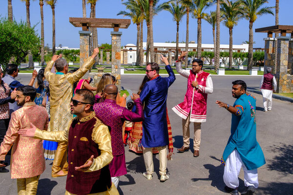 in front of the hotel there is a colorfully dressed indian wedding part