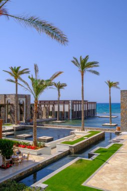 Havuz ve palmiye ağaçlarıyla çevrili bir otel kompleksi deniz tarafından kirletilmiştir.