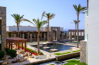 Havuz ve palmiye ağaçlarıyla çevrili bir otel kompleksi deniz tarafından kirletilmiştir.