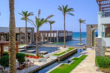 Havuz ve palmiye ağaçlarıyla çevrili bir otel kompleksi deniz tarafından kirletilmiştir.