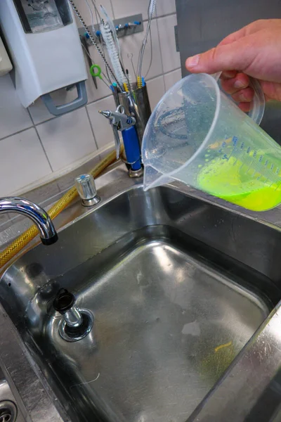 a neon green liquid is put into a water bath