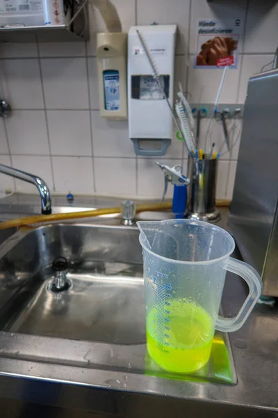 a neon green liquid is put into a water bath