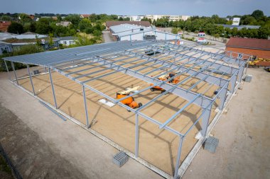 İnşaat alanında bir depo için çelik yapı iskelesi yapılıyor.