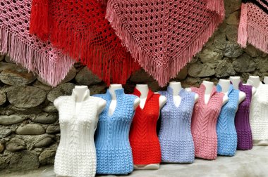 Colorful shawls and sweaters are sold in a small market  Kabardino-Balkaria. clipart