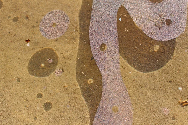 Ongewone plekjes van zand op het water — Stockfoto