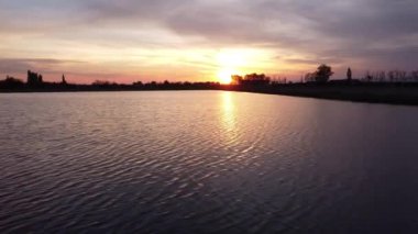 Sel basmış pirinç tarlasında gün batımı görüntüsü