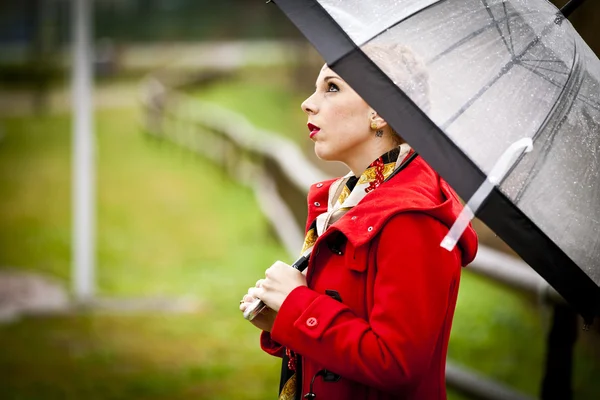 Samotna dziewczyna w parku w deszczowy dzień z parasolem — Zdjęcie stockowe