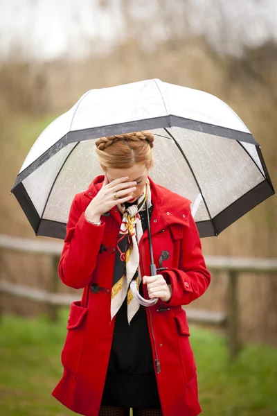 Samotna dziewczyna w parku w deszczowy dzień z parasolem — Zdjęcie stockowe