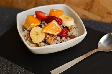 Siyah ahşap arka planda beyaz kasede chia tohumları olan meyve salatası. Üst Manzara. Yakın çekim..