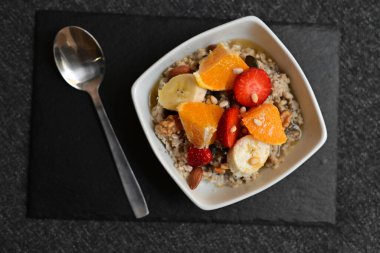 Siyah ahşap arka planda beyaz kasede chia tohumları olan meyve salatası. Üst Manzara. Yakın çekim..