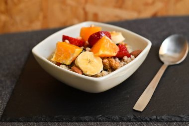 Siyah ahşap arka planda beyaz kasede chia tohumları olan meyve salatası. Üst Manzara. Yakın çekim..