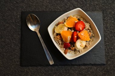 Siyah ahşap arka planda beyaz kasede chia tohumları olan meyve salatası. Üst Manzara. Yakın çekim..