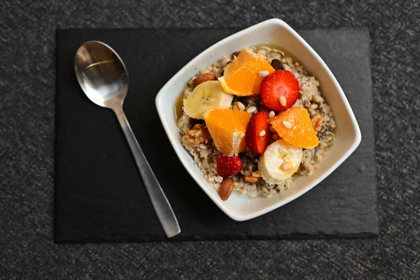 Siyah ahşap arka planda beyaz kasede chia tohumları olan meyve salatası. Üst Manzara. Yakın çekim..