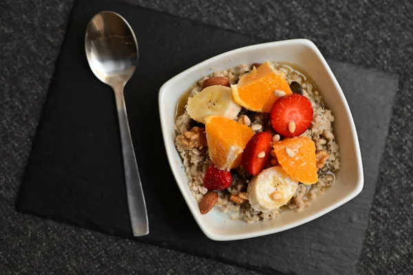 Siyah ahşap arka planda beyaz kasede chia tohumları olan meyve salatası. Üst Manzara. Yakın çekim..