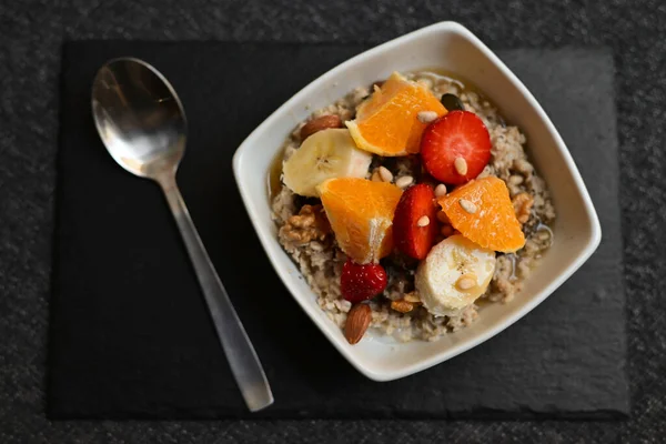 Siyah ahşap arka planda beyaz kasede chia tohumları olan meyve salatası. Üst Manzara. Yakın çekim..