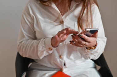 Ofiste akıllı telefon kullanan iş kadını: Modern cihazlar, dijital tablet bilgisayar ve cep telefonu ile çalışan iş kadını.