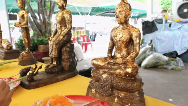Sebuah patung buddha dengan serpihan emas melambai di kuil — Stok Video