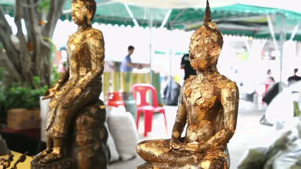 Estatuas de buda con hojuelas de oro ondeando en el templo — Vídeo de stock