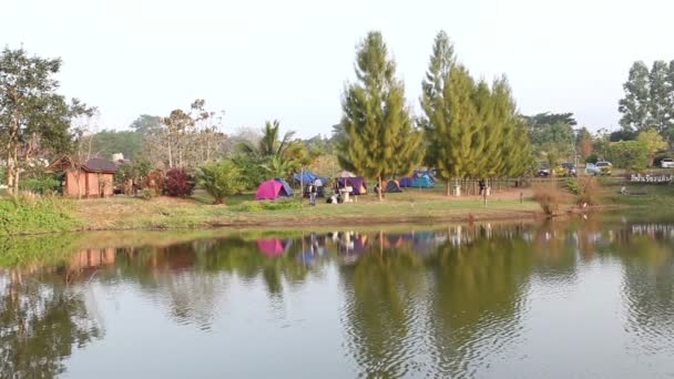 Ομάδα ανθρώπων να απολαύσουν στρατόπεδο σκηνή εκτός από τη φυσική λίμνη — Αρχείο Βίντεο