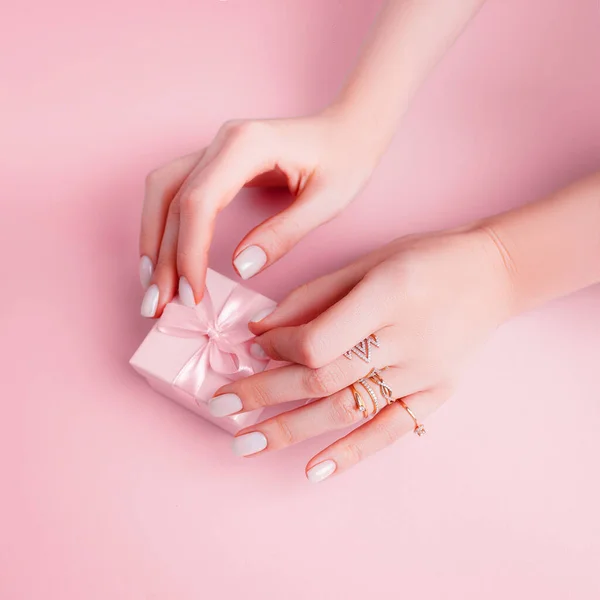 送给一个粉红背景的女孩粉红背景的修指甲手. — 图库照片