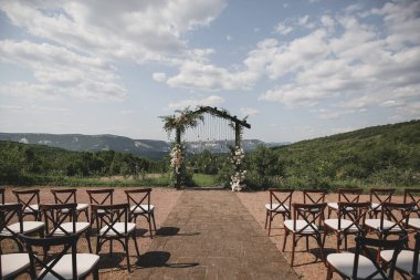 Boho stilinde düğün kemeri Parkta beyaz çiçekler ve ampuller.