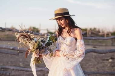 Çiftlikte boho tarzında bir düğün çifti. Tasarımcı düğün buketi.
