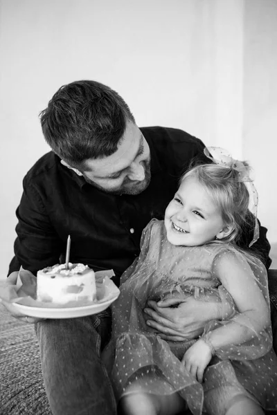 Far och dotter firar sin dotters födelsedag. Födelsedag firande i klänningar med tårta. — Stockfoto