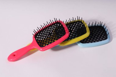 İzole edilmiş beyaz arka planda çok renkli saç tarakları. 