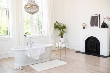 Büyük güneşli camları, dekorasyonu ve bitkileri olan beyaz, modern bir banyo. İç tasarım 