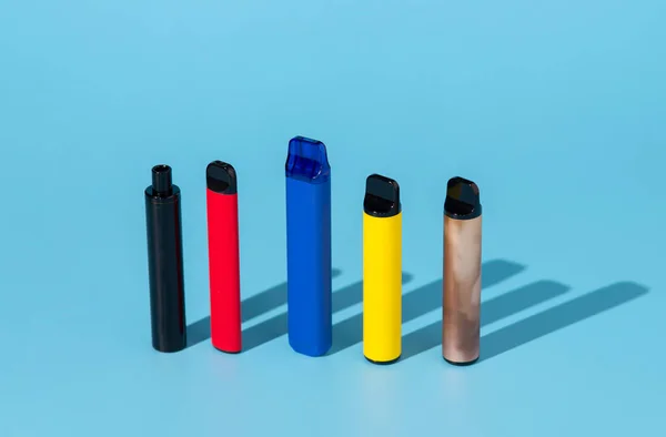 一套蓝色背景的彩色一次性电子香烟 现代吸烟的概念 — 图库照片