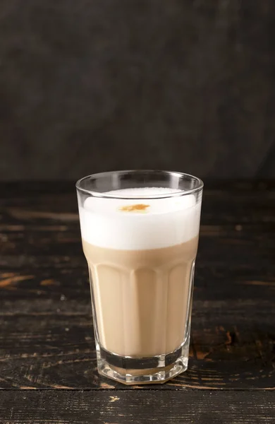 A glass of coffee on a wooden dark background. latte or cappuccino. coffee with milk. High quality photo