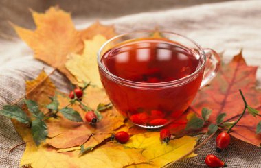 Cam bardakta taze böğürtlenli bir fincan gül kalçası çayı. Eski arkaplan, seçici odak.