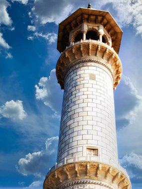 Agra, Uttar Pradesh, Hindistan 'da bulunan Tac Mahal' i çerçeveleyen dört minareden birinin mavi gökyüzü arkaplanına doğru bakın.