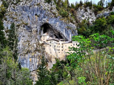 Predjama Slovenya, mağara girişinin önüne inşa edilmiş muhteşem taş kale, dik ve ulaşılamaz bir uçurumla korunuyor.