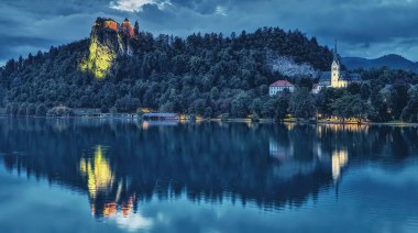 Bled Gölü su yüzeyine yansıyan gece Slovenya'da ışıklı Bled Castle