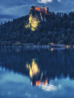 Bled Gölü su yüzeyine yansıyan gece Slovenya'da ışıklı Bled Castle