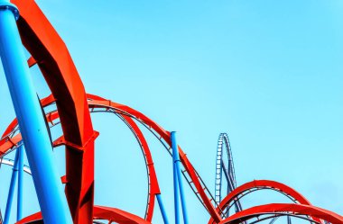 looping roller coaster on blue sky sunny day