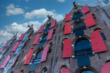 Amsterdam 'da kırmızı panjurlu eski bir Hollandalı evin cephesi.