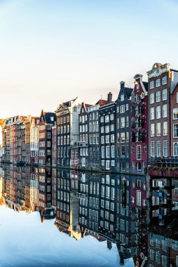 Amsterdam Şehir Sahnesi, tipik Hollandalı evleri ve kanaldaki yansımaları. Hollanda, Amsterdam 'ın merkezinde bir kanal boyunca eski 17. ve 18. yüzyıl tuğlalı evleri..