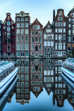 Amsterdam Şehir Sahnesi, tipik Hollandalı evleri ve kanaldaki yansımaları. Hollanda, Amsterdam 'ın merkezinde bir kanal boyunca eski 17. ve 18. yüzyıl tuğlalı evleri..