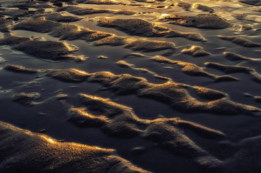 Deniz kenarında renkli bir gün batımı, güzel bir dalga deseni var..